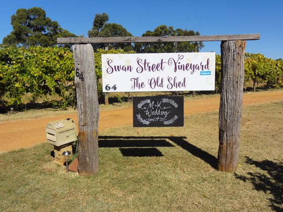 Freestanding LOVE letters and hay-bale seating set up for an outdoor wedding celebration in the vineyard.